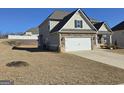 Exterior home view with a spacious yard, two-car garage, and neutral siding at 1455 Weeping Tree Cir, Auburn, GA 30011
