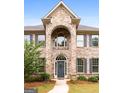 Two-story brick home with arched entryway and gray door at 870 N Bethany Rd, Mcdonough, GA 30252