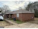 View of the brick exterior with a covered front porch area and parking at 241 E Ash St, Social Circle, GA 30025