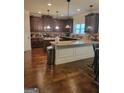 Spacious kitchen with dark wood cabinets, granite countertops, and hardwood floors at 65 Waters Edge Ln, Covington, GA 30014