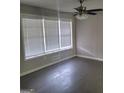 Bright bedroom featuring a large window with blinds, ceiling fan, and neutral paint at 304 Mercer Dr, Jonesboro, GA 30236