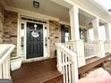 Inviting front porch featuring stone columns and a decorative 'Sweet Home' door wreath at 1320 Newbridge Cir, Buford, GA 30519