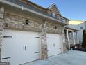 Close up of home's inviting two car garage and stone accents at 1320 Newbridge Cir, Buford, GA 30519