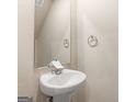 Neutral-toned powder room featuring a pedestal sink and a framed mirror at 144 Oliver Dr, Locust Grove, GA 30248