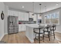 Modern kitchen with stainless steel appliances, white cabinets, quartz counters and a central island with bar stool seating at 720 Lanarck Way, Peachtree City, GA 30269