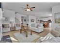 Open-concept living room with modern decor, wood floors, and ample natural light adjacent to the kitchen at 720 Lanarck Way, Peachtree City, GA 30269