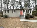 Charming gray brick ranch home with updated landscaping and a vibrant coral door at 425 Cologne Se Dr, Atlanta, GA 30354