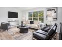 Airy living room with modern furniture, hardwood floors, and abundant natural light from a large window at 3831 Flakes Mill Rd, Decatur, GA 30034