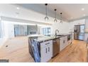 Open kitchen with island, stainless steel appliances, and hardwood floors, overlooking the living area at 2110 Fairway Ne Cir, Brookhaven, GA 30319