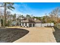 Two-story house with a gray roof, white exterior, and a large driveway at 103 Sandtrap Rdg, Peachtree City, GA 30269