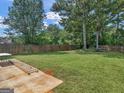 Expansive, fully fenced backyard showcasing lush lawn and mature trees, perfect for outdoor activities and relaxation at 2110 Kellington Dr, Mcdonough, GA 30253