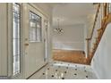 Bright foyer with marble tile, chandelier view into the dining room and wooden staircase at 337 Legacy Ln, Peachtree City, GA 30269