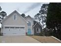 Two-story home with grey and stone facade and a manicured lawn and a bright blue front door at 205 Belvedere Green, Peachtree City, GA 30269