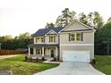Traditional two-story home with a gray exterior, dark shutters, a covered porch, and a well-maintained lawn at 142 Tye St, Stockbridge, GA 30281