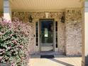 Front entrance with glass paneled door, sidelights, brick surround, and flowering shrubbery at 137 Nobility Ln, Mcdonough, GA 30252