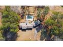 A luxurious backyard featuring a pool, a landscaped garden, and a lovely brick home and driveway at 160 Appalachee Church Rd, Auburn, GA 30011