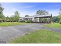 Exterior view of home featuring covered carport and a long gravel driveway at 382 Lamb Rd, Moreland, GA 30259