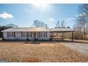 Charming home featuring a metal roof, red shutters, and covered parking with a deck at 382 Lamb Rd, Moreland, GA 30259