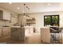 Bright kitchen with marble island, wooden accents, stainless steel appliances, pendant lighting, and a view to the backyard at 330 Campground Rd, Mcdonough, GA 30253