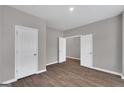 Neutral bedroom featuring wood-look flooring and three white doors at 5343 Tolar Rd # 58, South Fulton, GA 30213