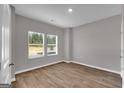 Neutral bedroom showcasing wood-look flooring, two windows, and white trim at 5343 Tolar Rd # 58, South Fulton, GA 30213