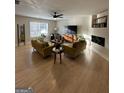 Bright living room with two sofas, a large window, and an electric fireplace with display shelves at 7050 Galloway Pt, Riverdale, GA 30296