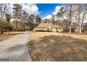 Wide view of a brick home with a large front yard and paved driveway at 195 Youngs Cir, Fayetteville, GA 30215