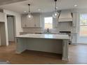Gorgeous kitchen with a large island, pendant lighting, stainless appliances and light gray cabinets at 130 Dockside Dr # 380, Fayetteville, GA 30215