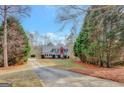 A stunning two-story home is nestled among trees with a long driveway at 25 Grange Way, Sharpsburg, GA 30277