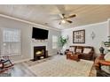 Cozy living room with shiplap wall, fireplace, ceiling fan, and comfortable leather sofas at 25 Grange Way, Sharpsburg, GA 30277