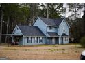 Classic two-story home showcases a blue exterior, dark roof, covered parking, and a well-manicured lawn with mature trees at 3281 Nina Way, Douglasville, GA 30135