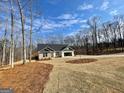 Scenic view of single-story home and lengthy driveway surrounded by trees and ample space at 3382 Milan Ct # 3 Plapprox Sqft 3, Douglasville, GA 30135