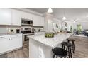 Modern kitchen with stainless steel appliances, granite countertops, and an island with bar seating at 1492 Trellis Court (Lot 44), Hampton, GA 30228