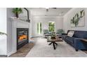 Bright living room features a fireplace, modern furniture, and natural light from large windows at 1492 Trellis Court (Lot 44), Hampton, GA 30228
