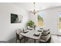 Elegant dining room featuring a modern chandelier, a window view, and seating for eight at 153 Cedar Ridge Rd, Locust Grove, GA 30248