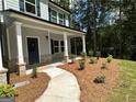 Landscaped front yard with mulch beds, a walkway to the front door, and lush greenery at 1825 Harmony Trce # 6, Lithonia, GA 30058