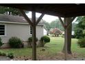 View of a large backyard with mature trees and landscaping, as seen from under a covered area at 2421 Rockbridge Sw Rd, Stone Mountain, GA 30087