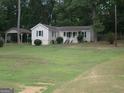 Charming single-story home with a covered front porch and a large front yard, plus a carport at 2421 Rockbridge Sw Rd, Stone Mountain, GA 30087