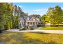Beautiful two-story home with a well-manicured lawn and driveway in a serene, wooded setting at 101 Kenmare Row, Tyrone, GA 30290