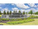 Community entrance monument with lush landscaping, a water feature, and Champions Run signage at 8591 Seabiscuit Rd # 113, Lithonia, GA 30058