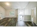 Bright living room with hardwood flooring, large window, fireplace, and access to the upper-level stairs at 5827 Highgrove Dr, Atlanta, GA 30349