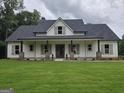 Charming single-story home with a welcoming front porch and lush green lawn at Lot C Montannas Way, Moreland, GA 30259
