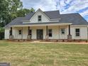 Beautifully constructed single story home showcasing a covered front porch and professional landscaping at Lot C Montannas Way, Moreland, GA 30259