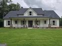 Charming single-story home with a welcoming front porch and lush green lawn at Lot C Montannas Way, Moreland, GA 30259