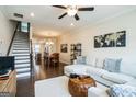 Bright, open-concept living area boasts hardwood floors, a modern ceiling fan, and flows into the dining area at 2624 Caruso Way, Atlanta, GA 30339