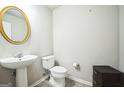 Powder room features modern vanity with pedestal sink and a gold framed mirror at 7764 Parkside Dr, Lithia Springs, GA 30122