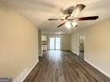 Spacious living room featuring wood-look flooring, neutral paint, and sliding glass doors at 2060 Sanders Dr, Austell, GA 30168