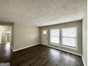 Bright living room with hardwood floors, a white front door, and large windows providing natural light at 1785 San Gabriel Ave, Decatur, GA 30032