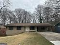 Charming single-story home featuring a covered carport and mature trees in a quiet neighborhood at 6982 Knollwood Dr, Morrow, GA 30260