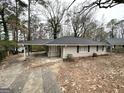 Ranch-style home features a carport, brick exterior, and a yard with mature trees at 1761 Carter Cir, East Point, GA 30344
